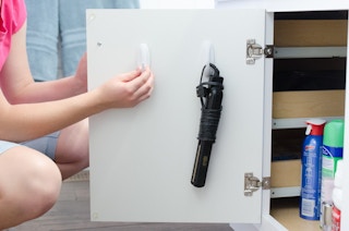 Hang styling tools to the inside of cabinets with adhesive hooks.