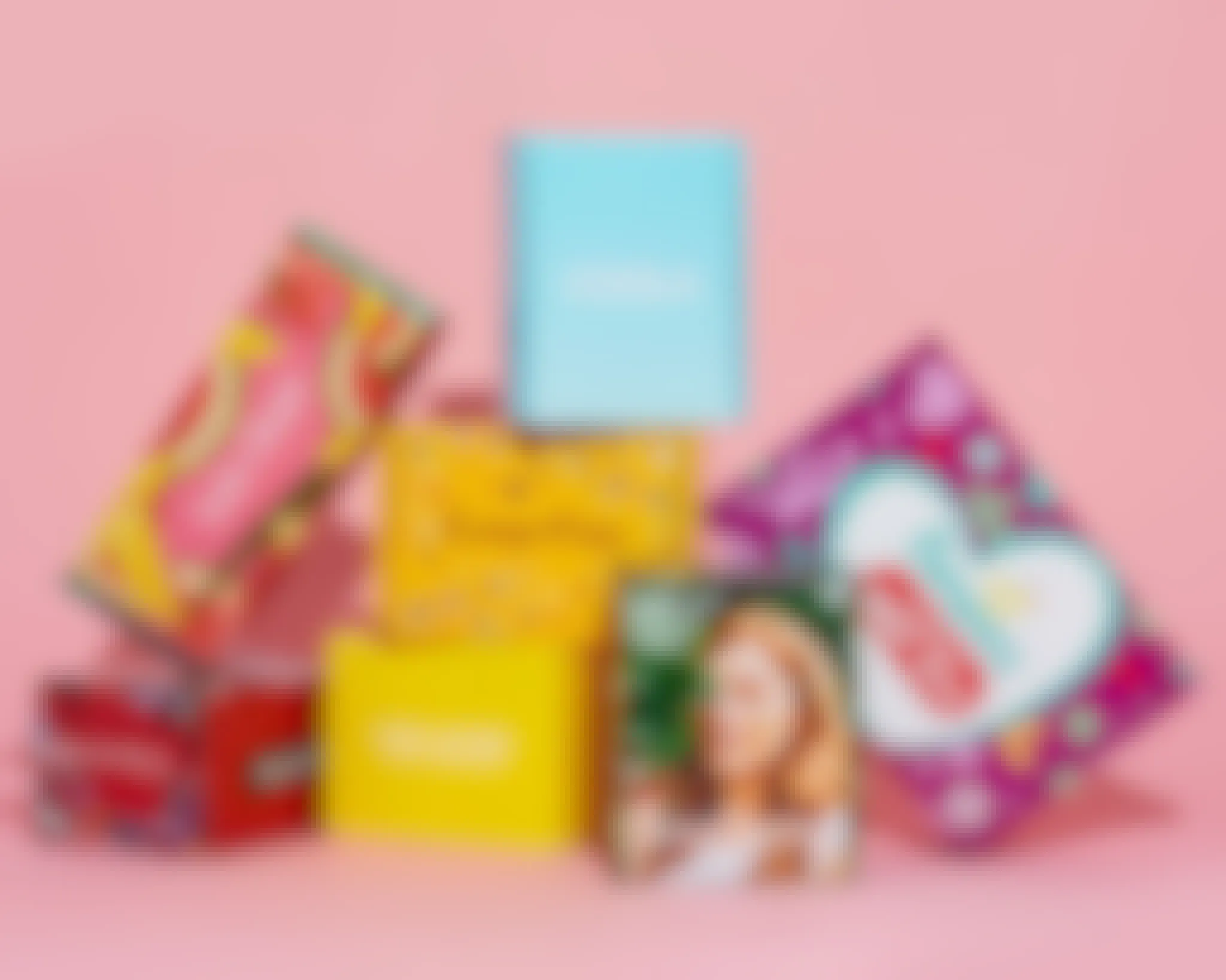 7 free sample boxes from Inflenster stacked on top of each other, on a pink background.