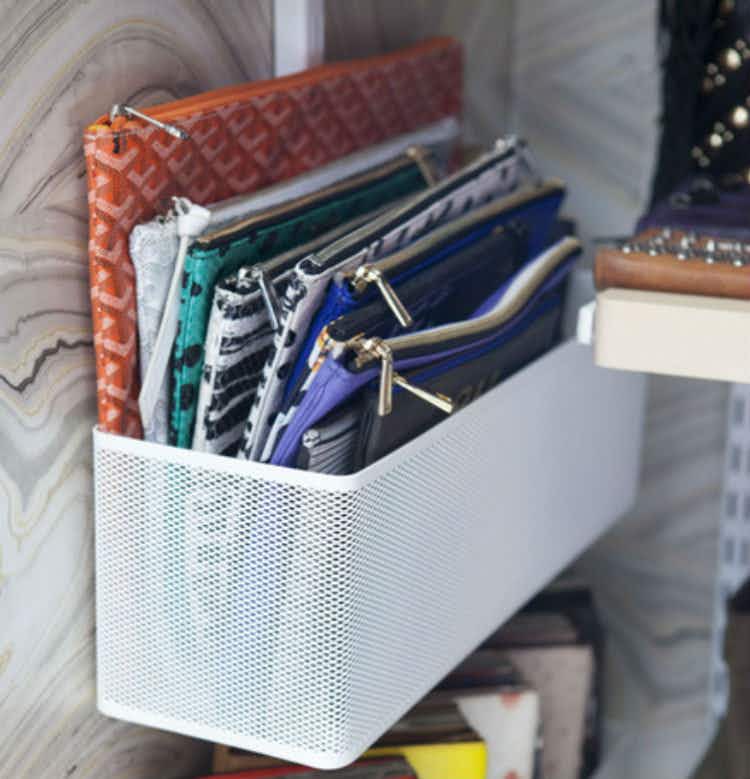 Hang metal shelves on the side of a closet to hold travel bags.