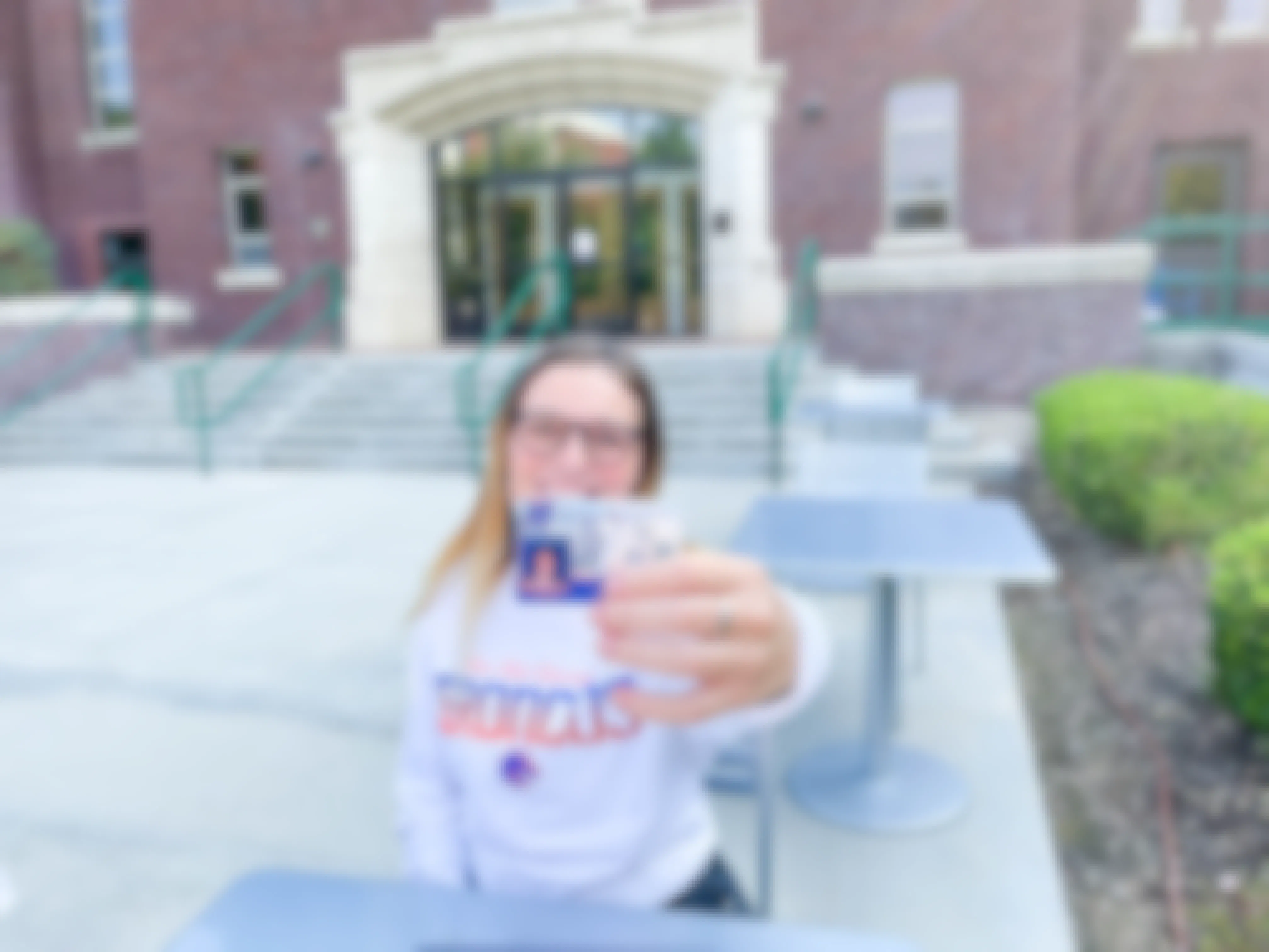 college student outside holding student id