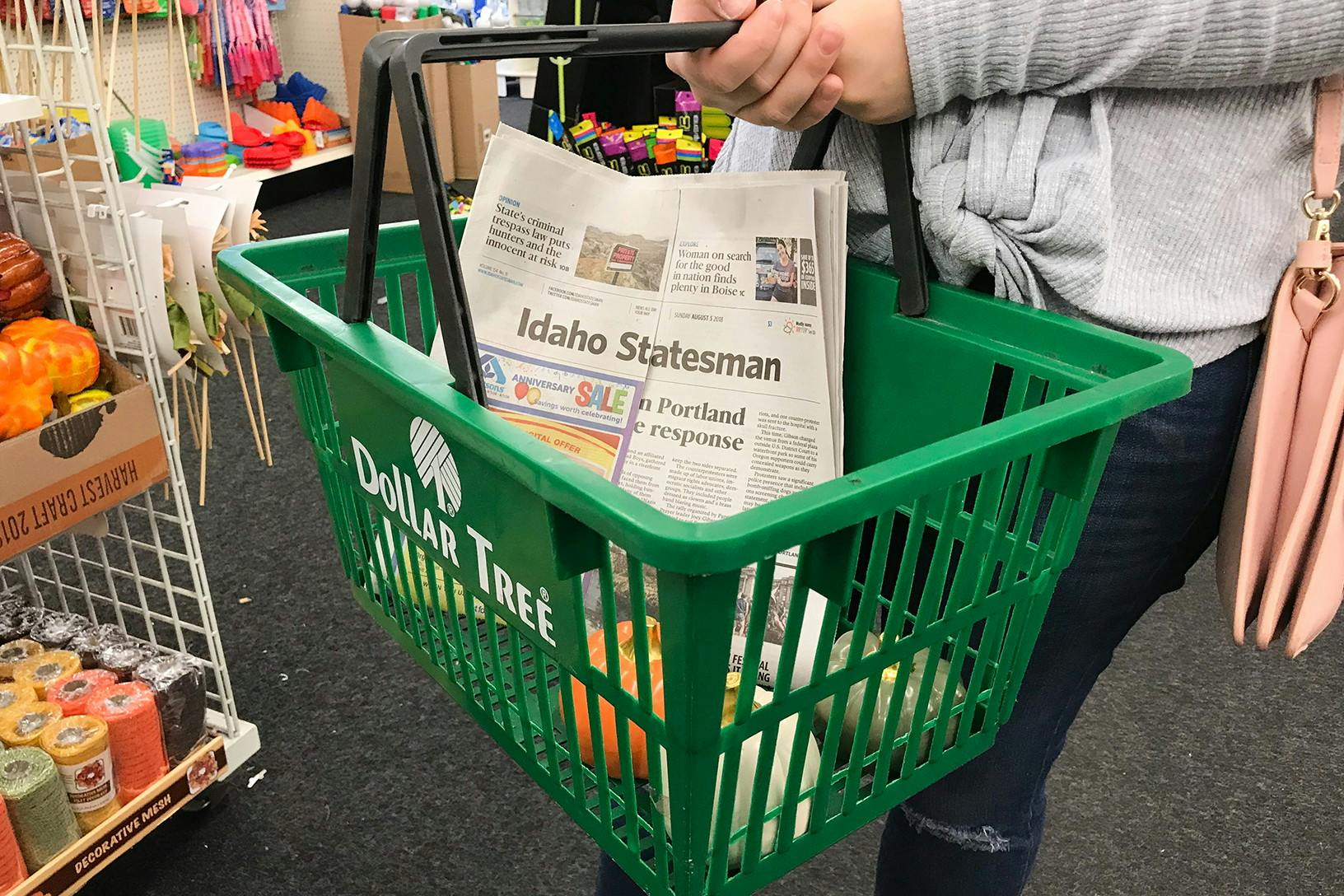 someone holding dollar tree basket with paper in it