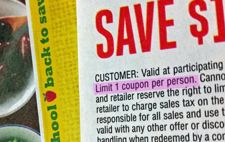 A close up on a coupon showing the fine print highlighted which says, "Limit 1 coupon per person