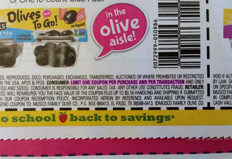 A close up on a coupon for olives with the fine print highlighted that says, "Limit one coupon per purchase and per transaction