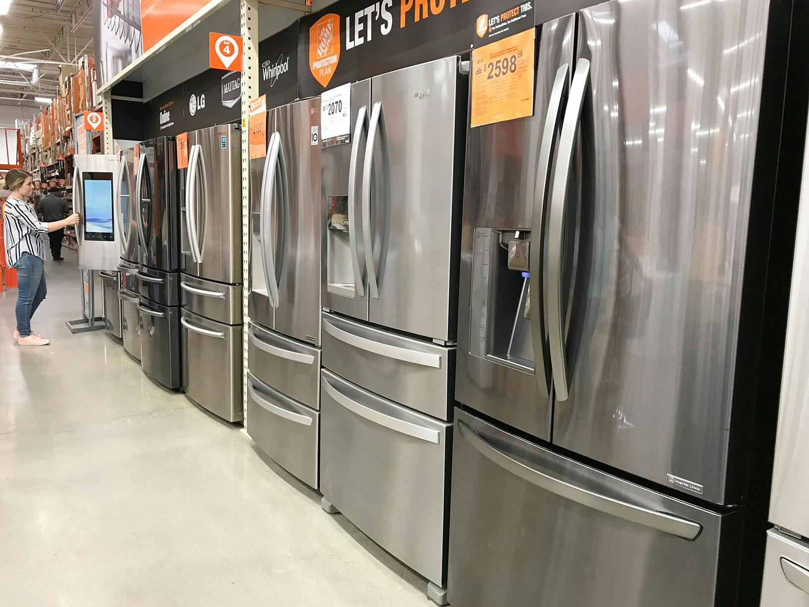 A row of refrigerators on display at Home Depot.