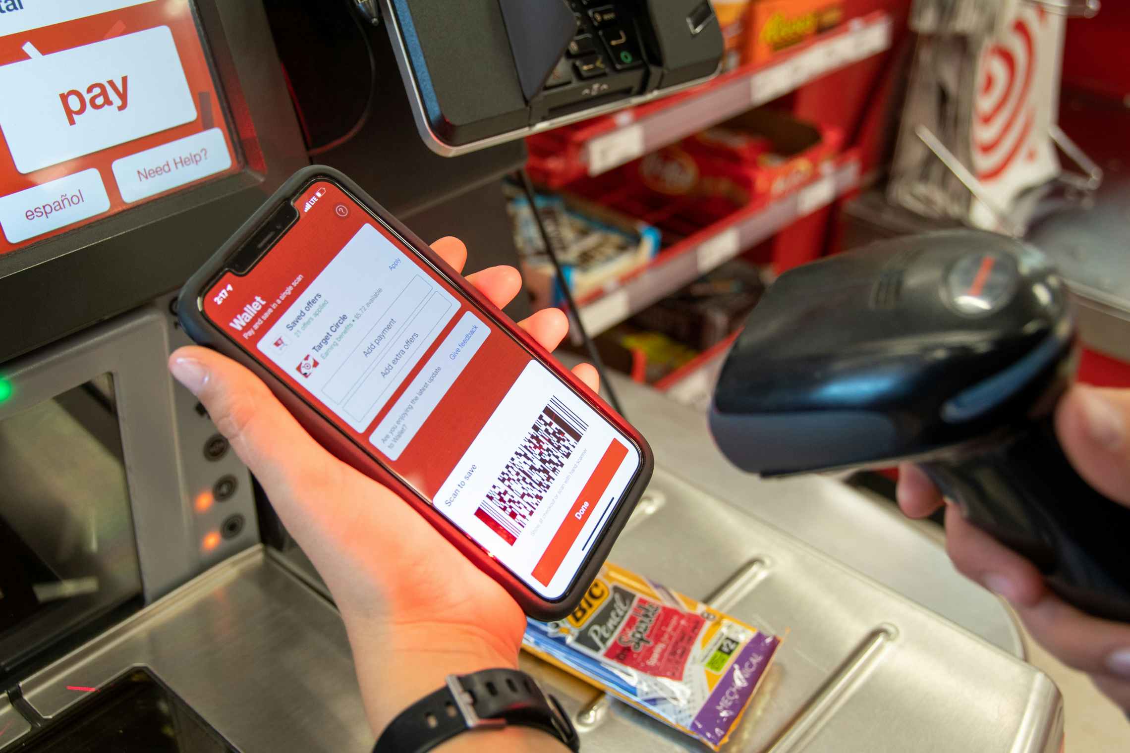 A woman scanning here Target app at a self-checkout register.