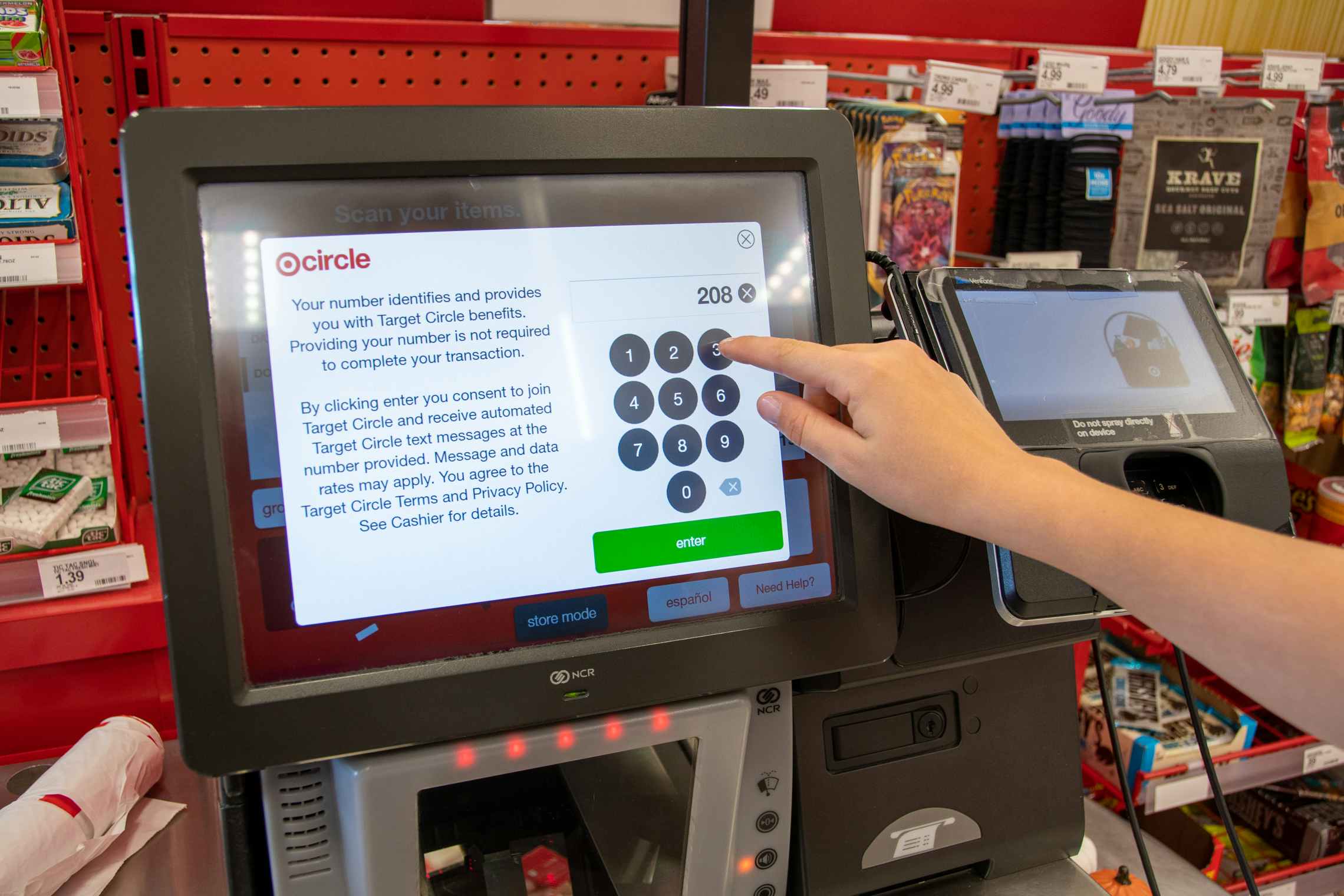A person typing in their phone number for Target Circle at self-checkout.