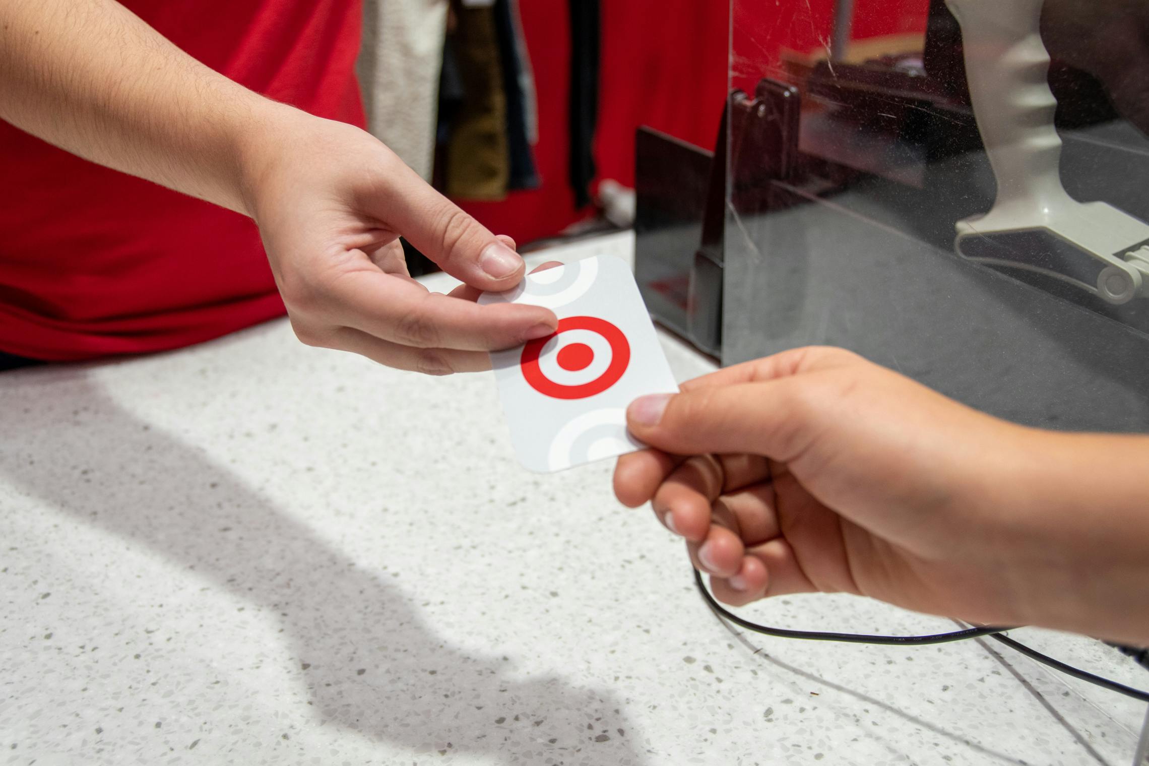 A Target employee handing someone a Target gift card at the register.
