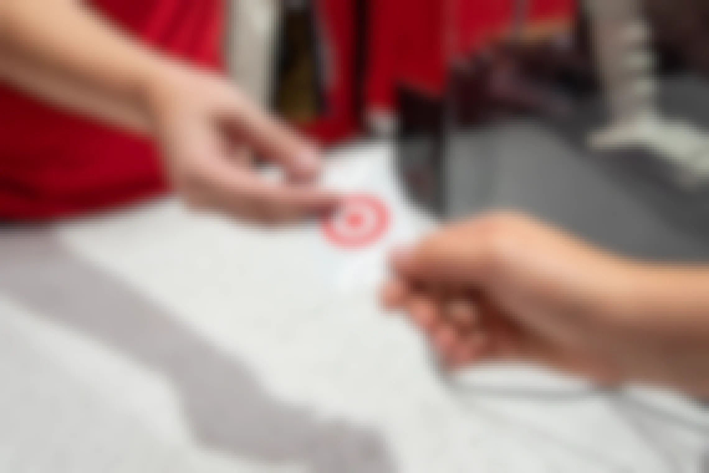 A Target employee handing someone a Target gift card at the register.