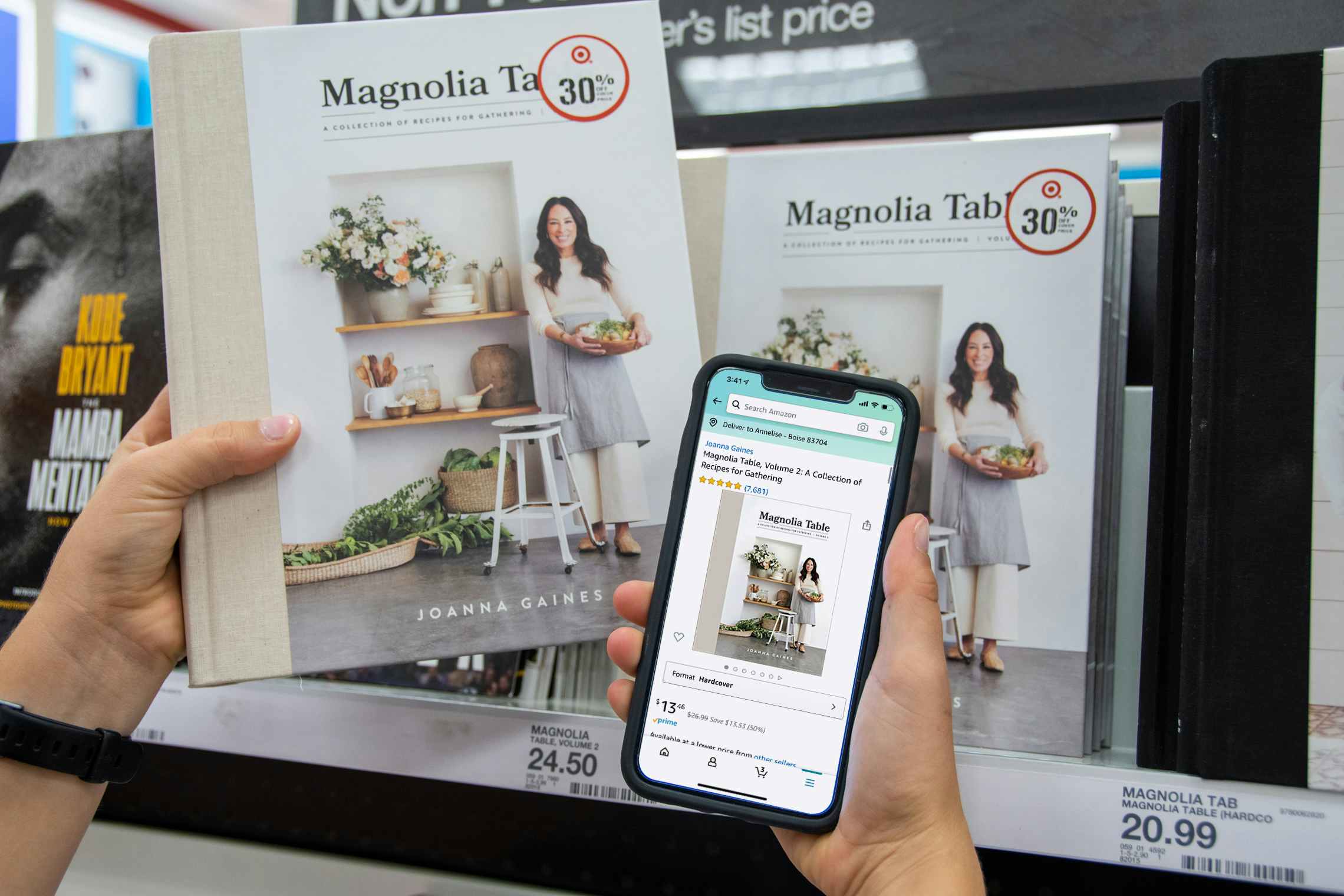 A copy of Magnolia Table held next to a cell phone displaying a lower price on the Amazon app.