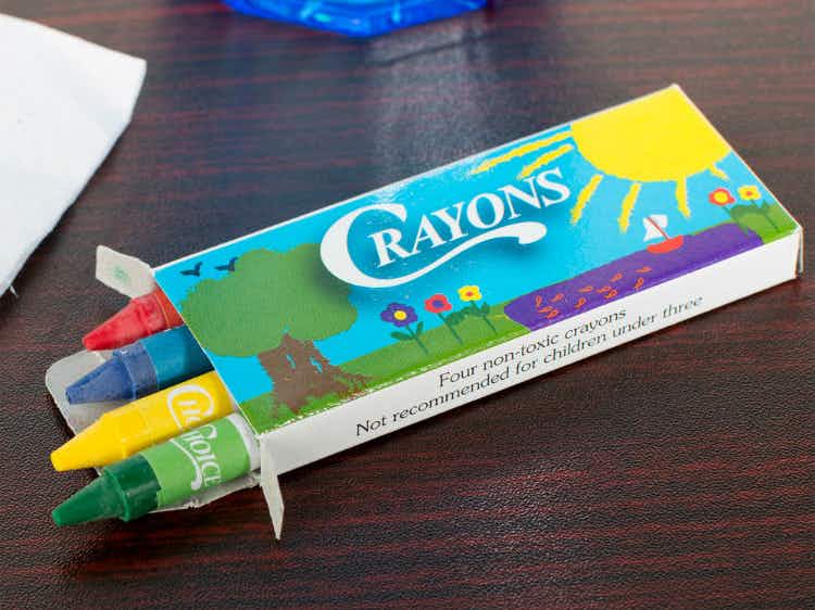 A box of four crayons open on a table.