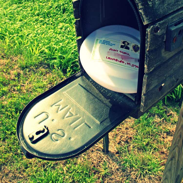 Toss a frisbee into the mail.