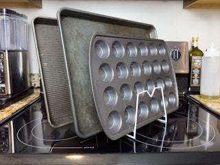 Some baking sheet pans and muffin tin organized with a small rack