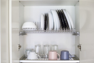 A dish drying rack inside a kitchen cabinet