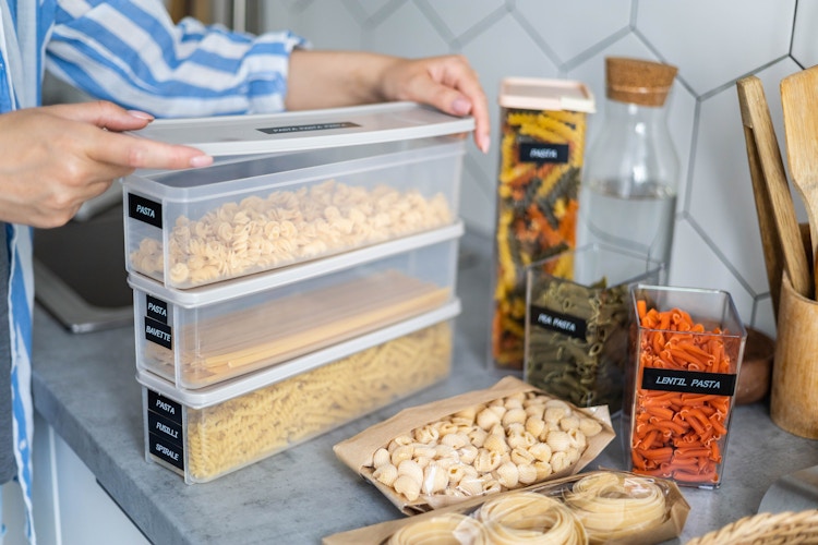 Someone packing foods into labeled containers to store them