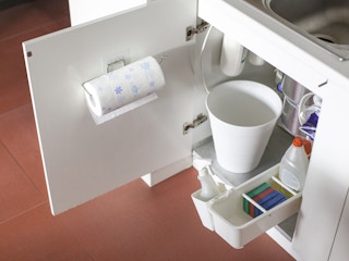 A paper towel roll attached to the inside of a kitchen cabinet door