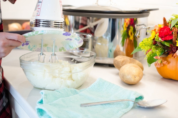 Someone using a paper plate as a hand-mixer splash guard.