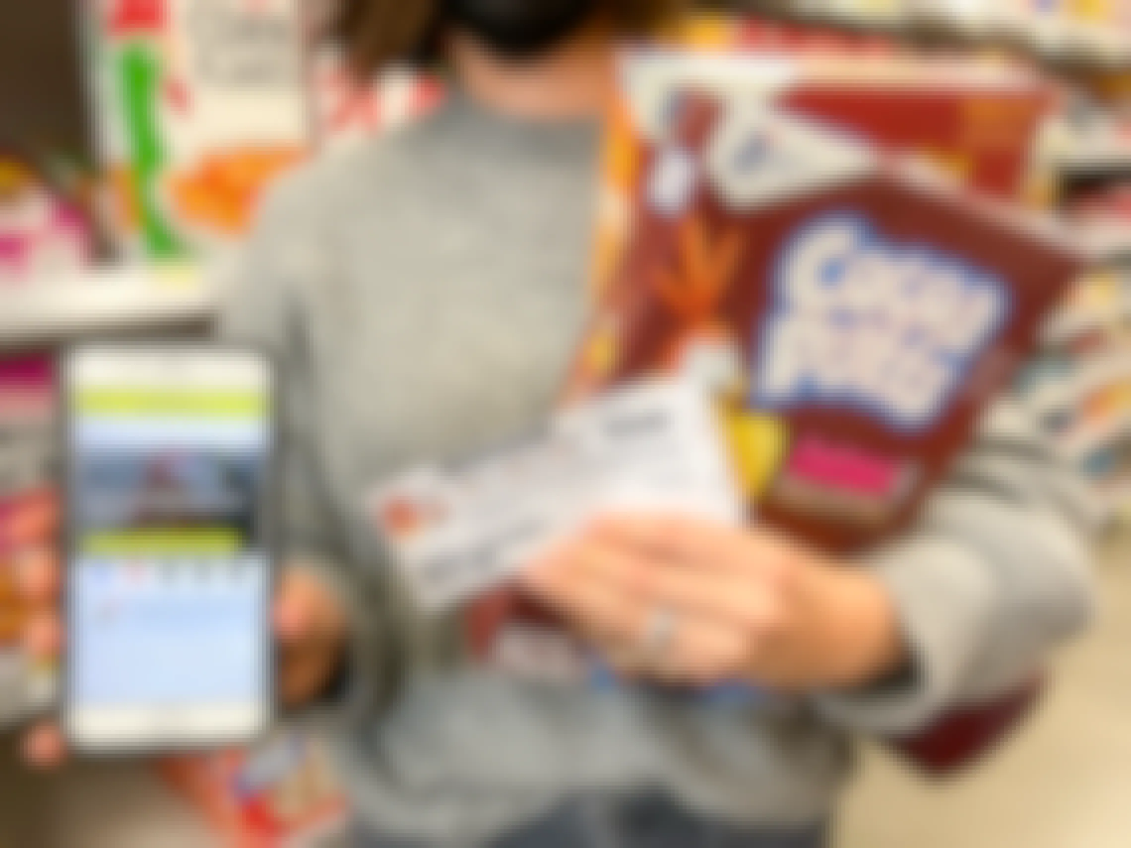 woman holding cocoa puffs, coupon and phone with kcl app