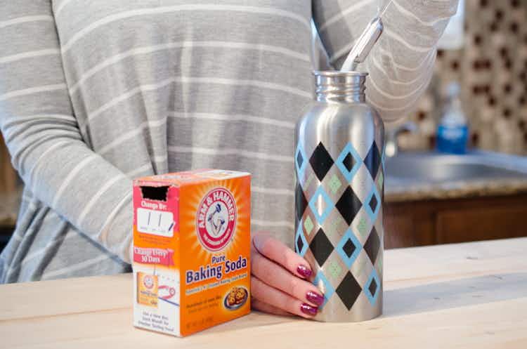Baking soda being poured into a water bottle.
