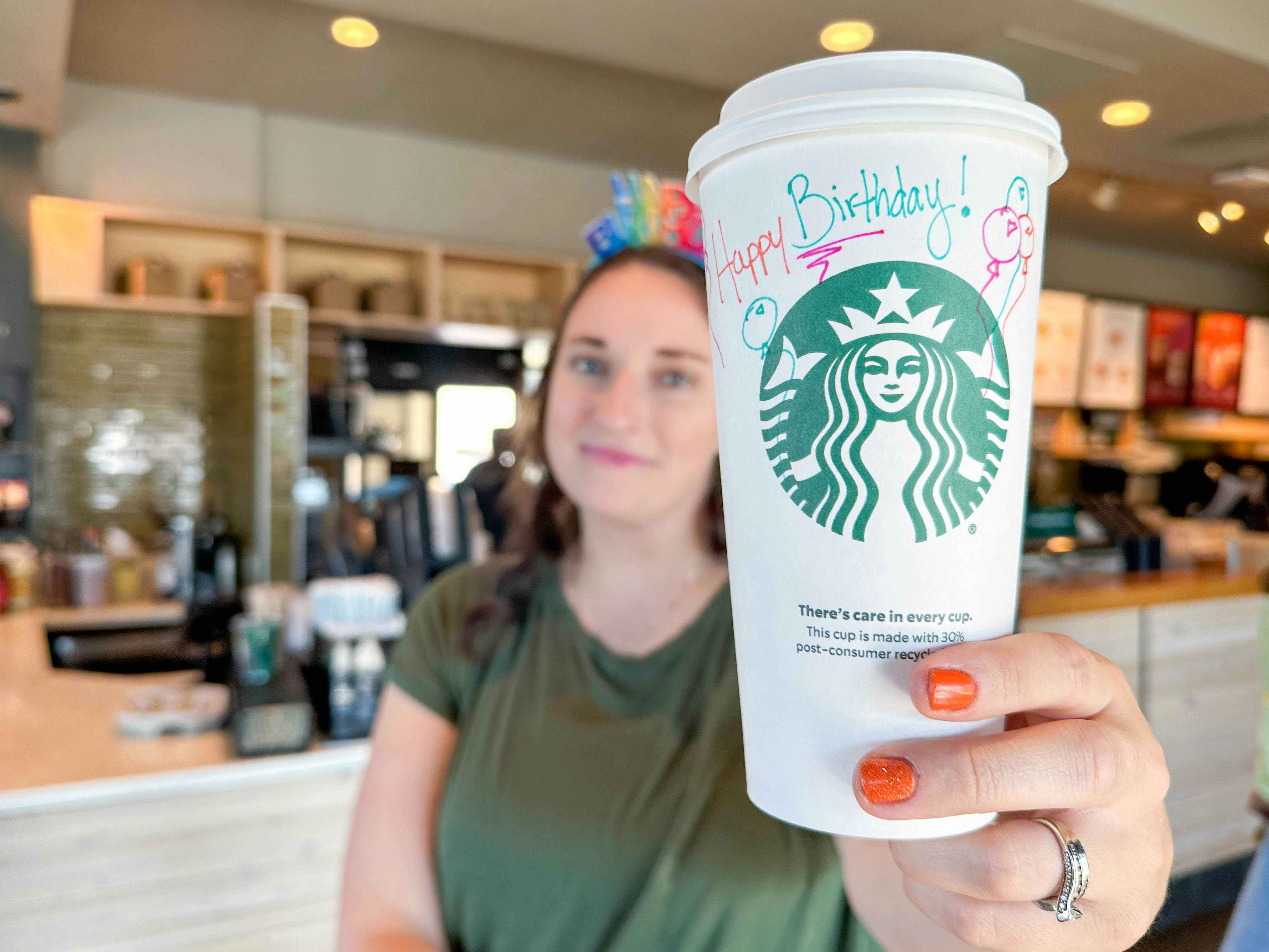 woman holding a happy birthday starbucks cup in store 