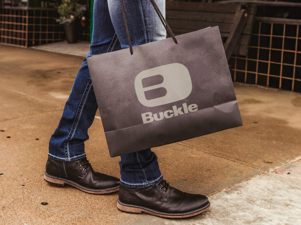 someone holding a bag from Buckle