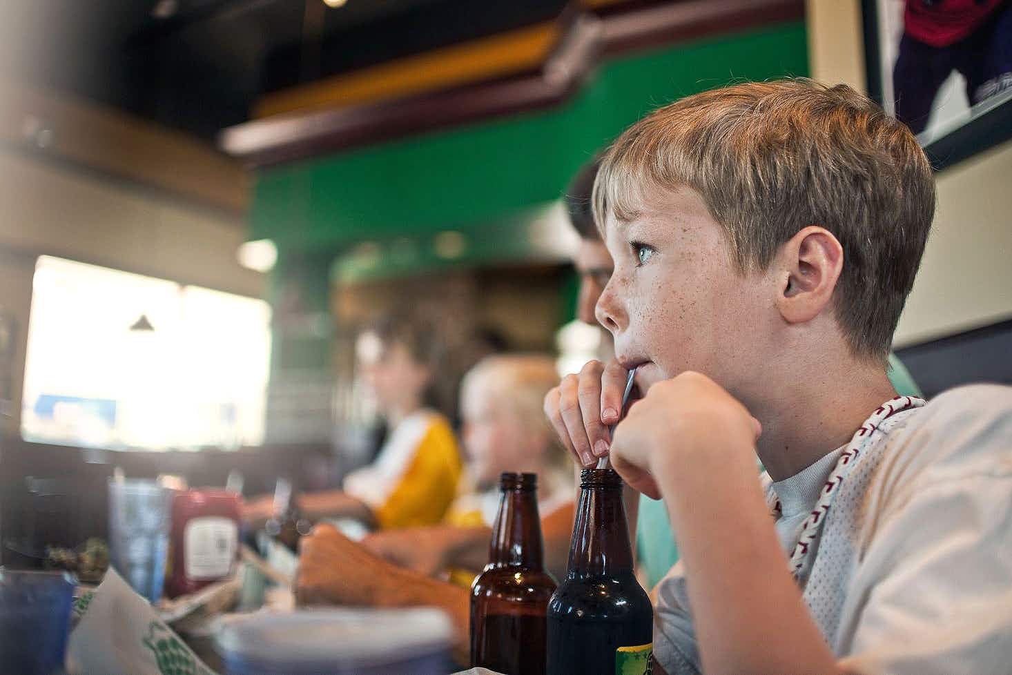 child drinking a soda at the greene turtle restaurant