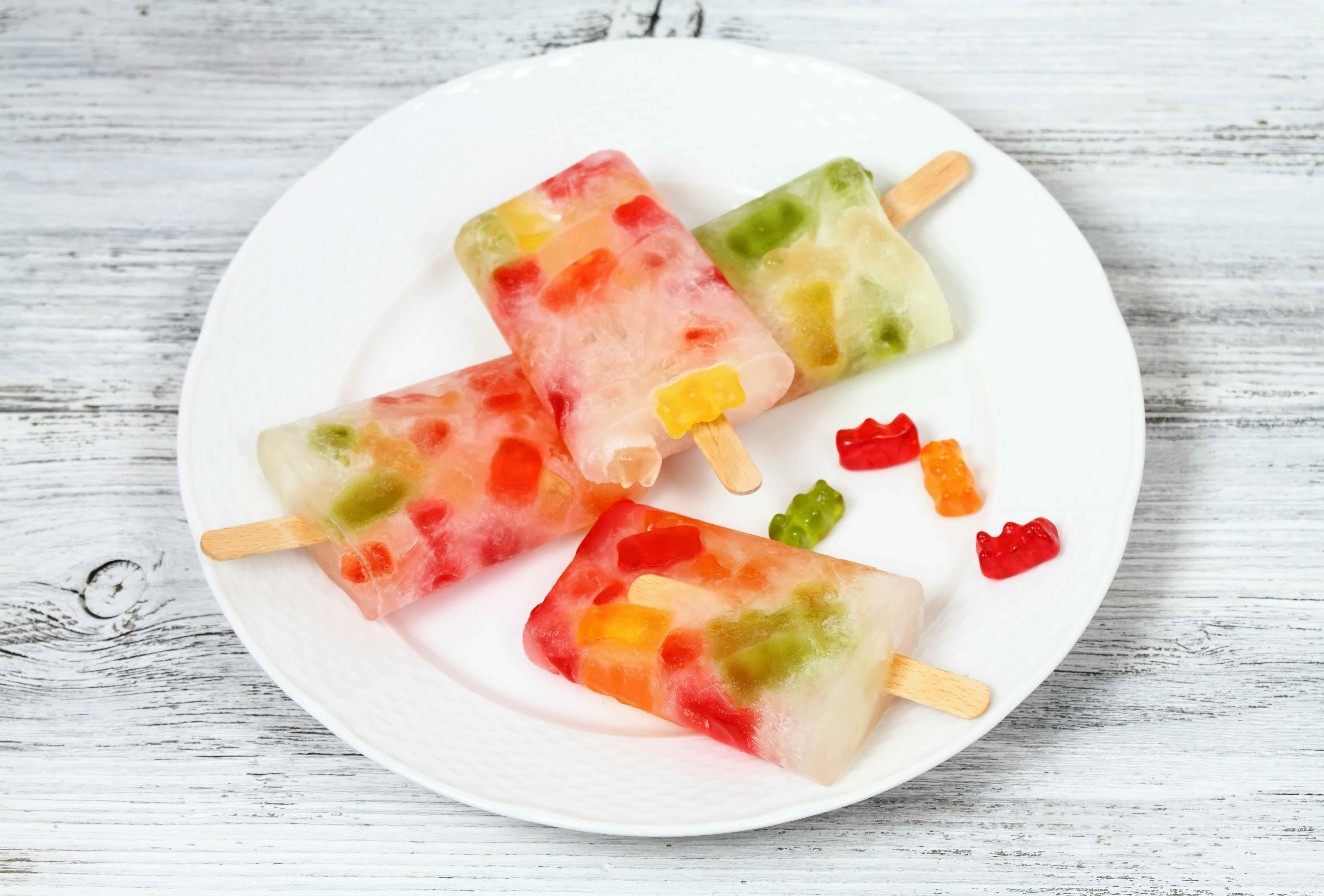 Popsicles made with gummi bears sitting on a plate