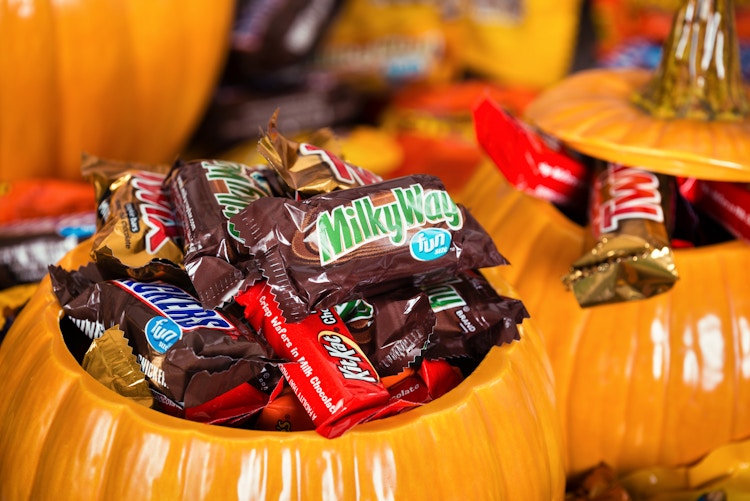 Ceramic pumpkin jars filled with Halloween candy.