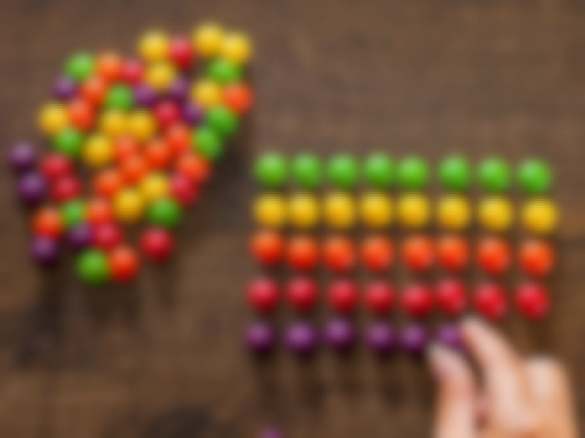 A person sorting skittles by color