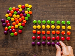 A person sorting skittles by color