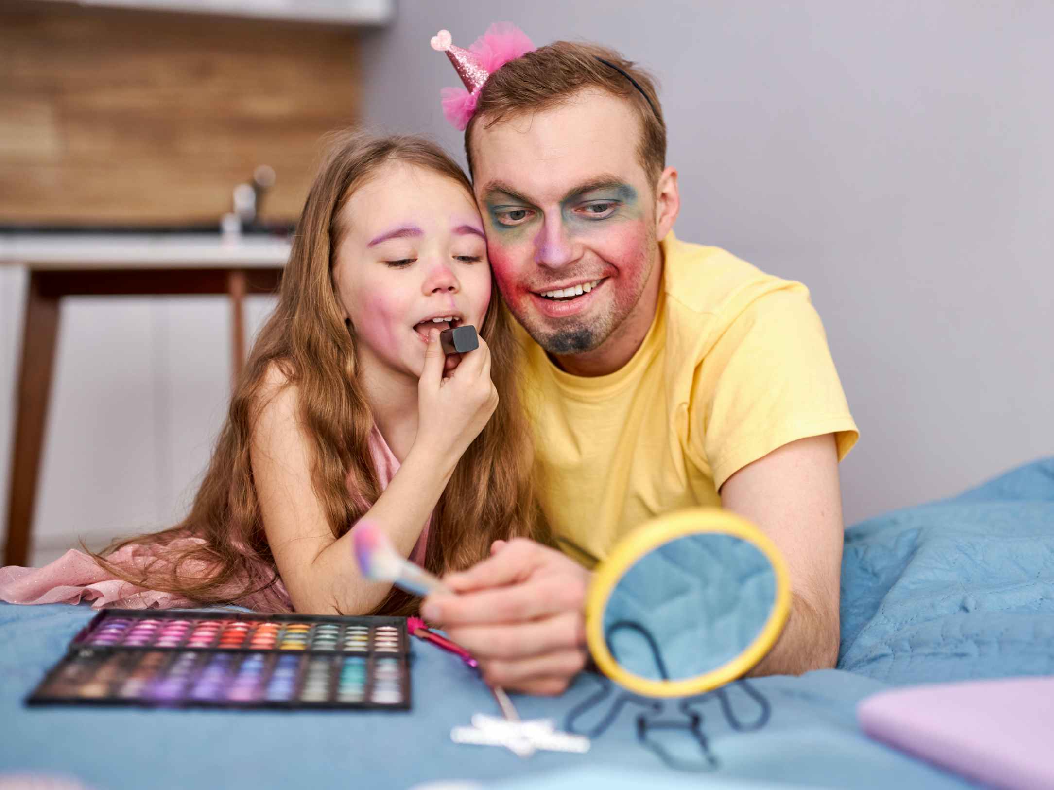 A father and daughter doing makeup together using costume makeup