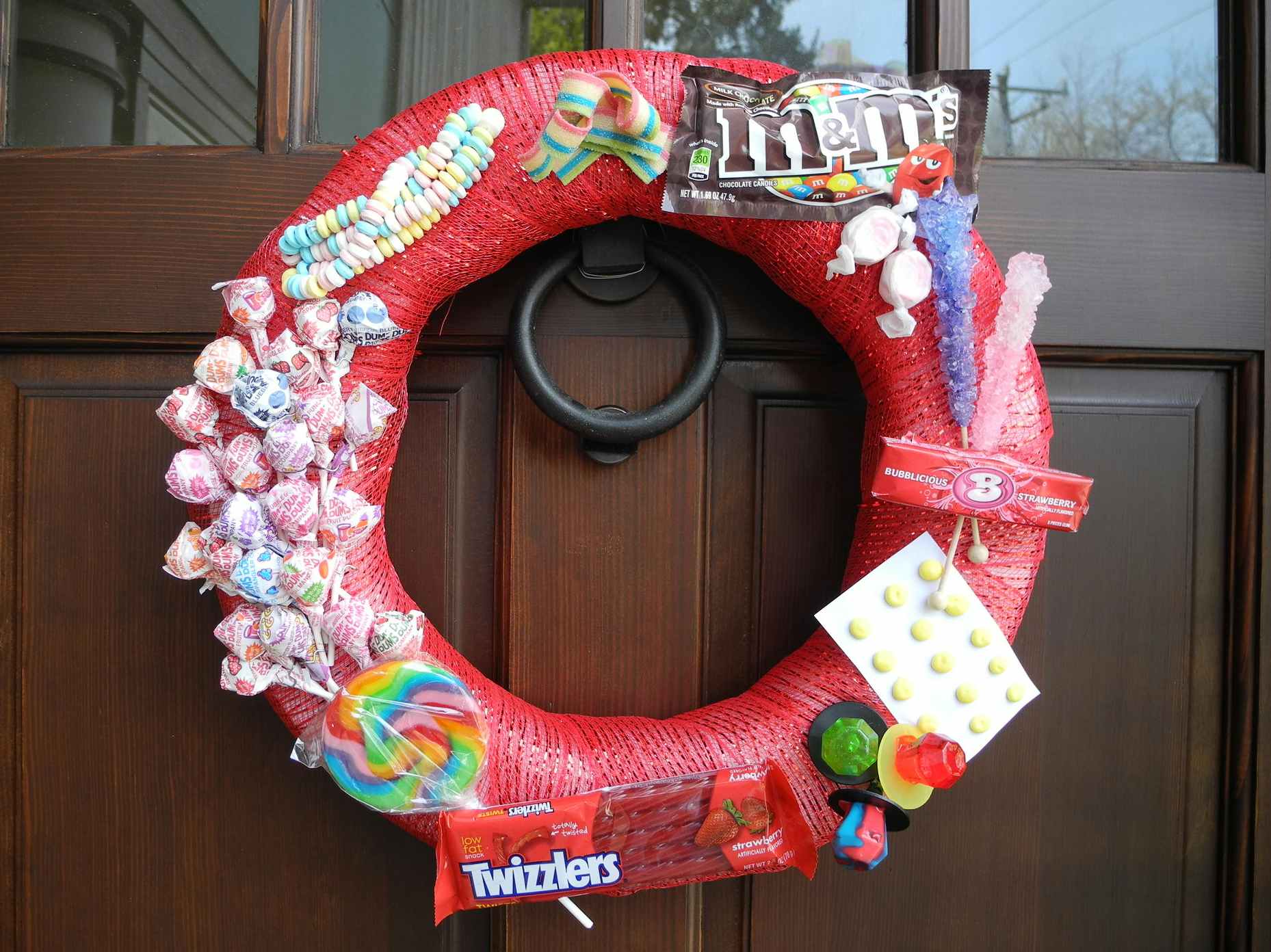 A Christmas door wreath decorated in Halloween candy.