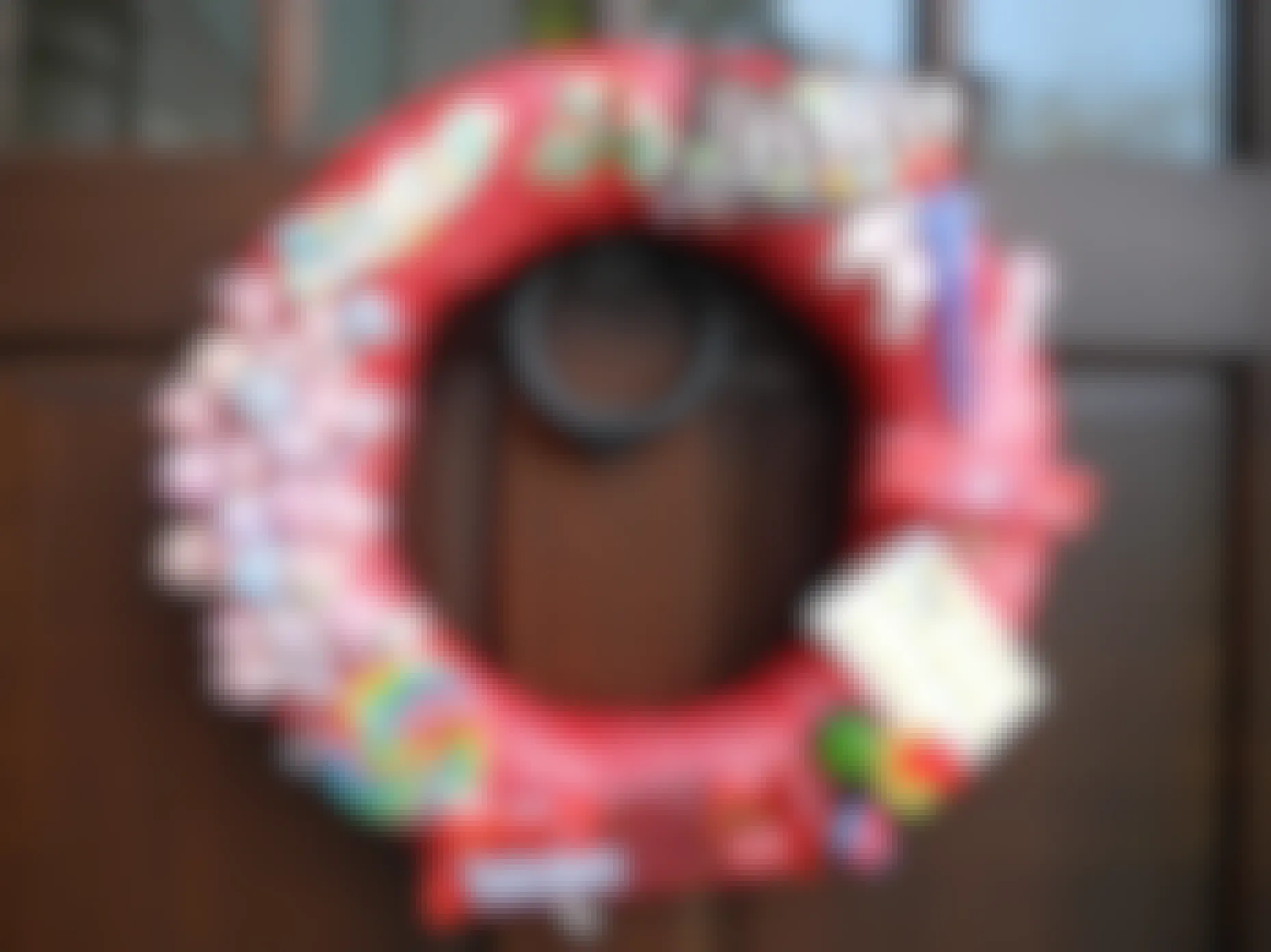 A Christmas door wreath decorated in Halloween candy.
