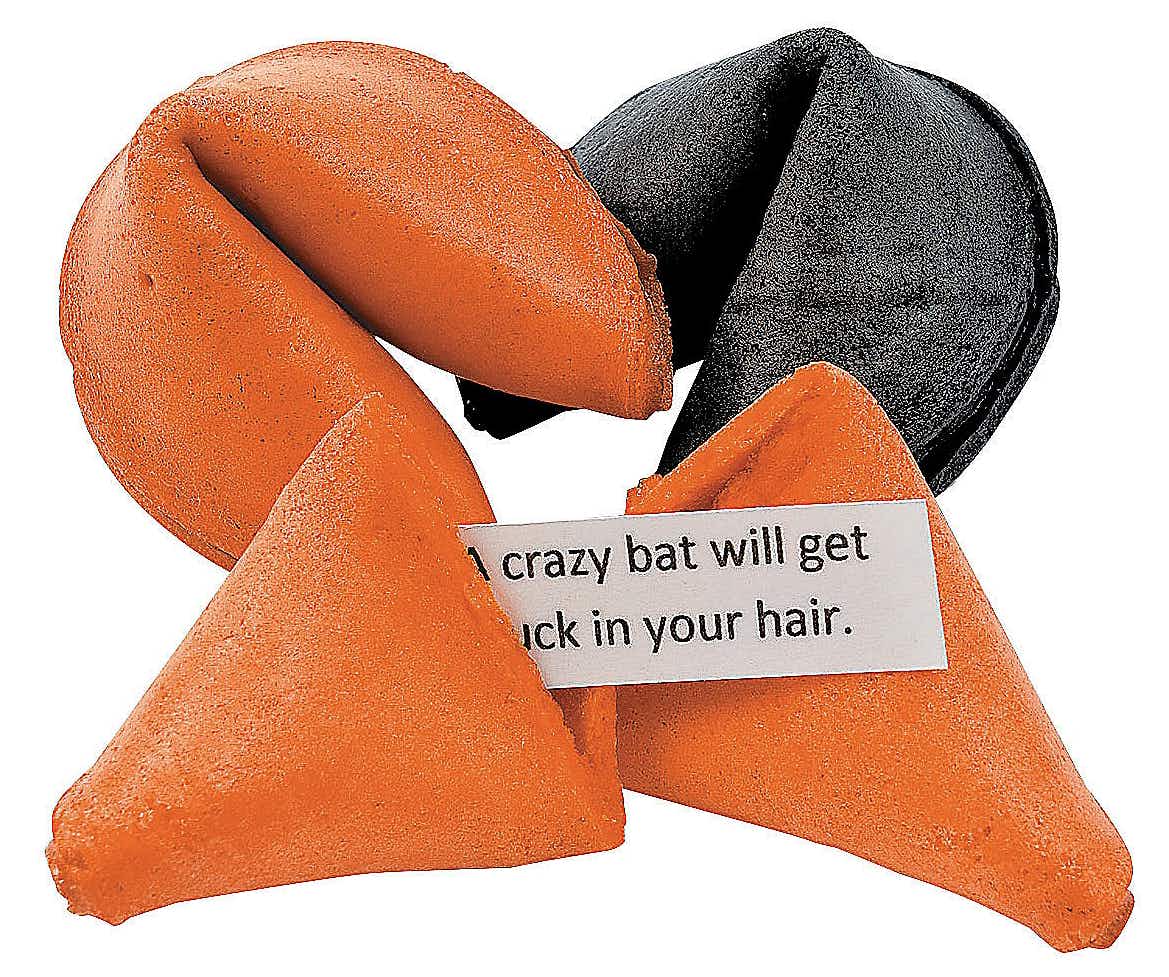 Orange and black fortune cookies with a piece of paper that reads, "A crazy bat will get stuck in your hair" on a white background.