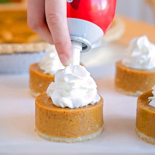 adding redi-whip to top of mini pumpkin pies