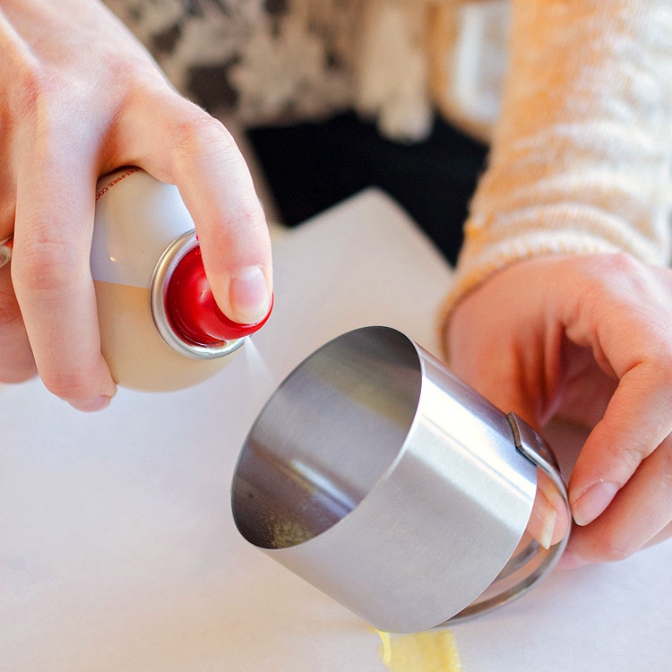 spraying cookie spray into biscuit cutter