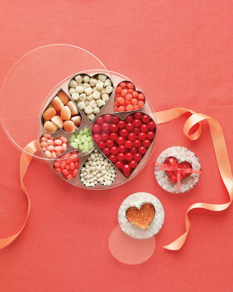 Organize the fruit, cheese, and candies in party trays.