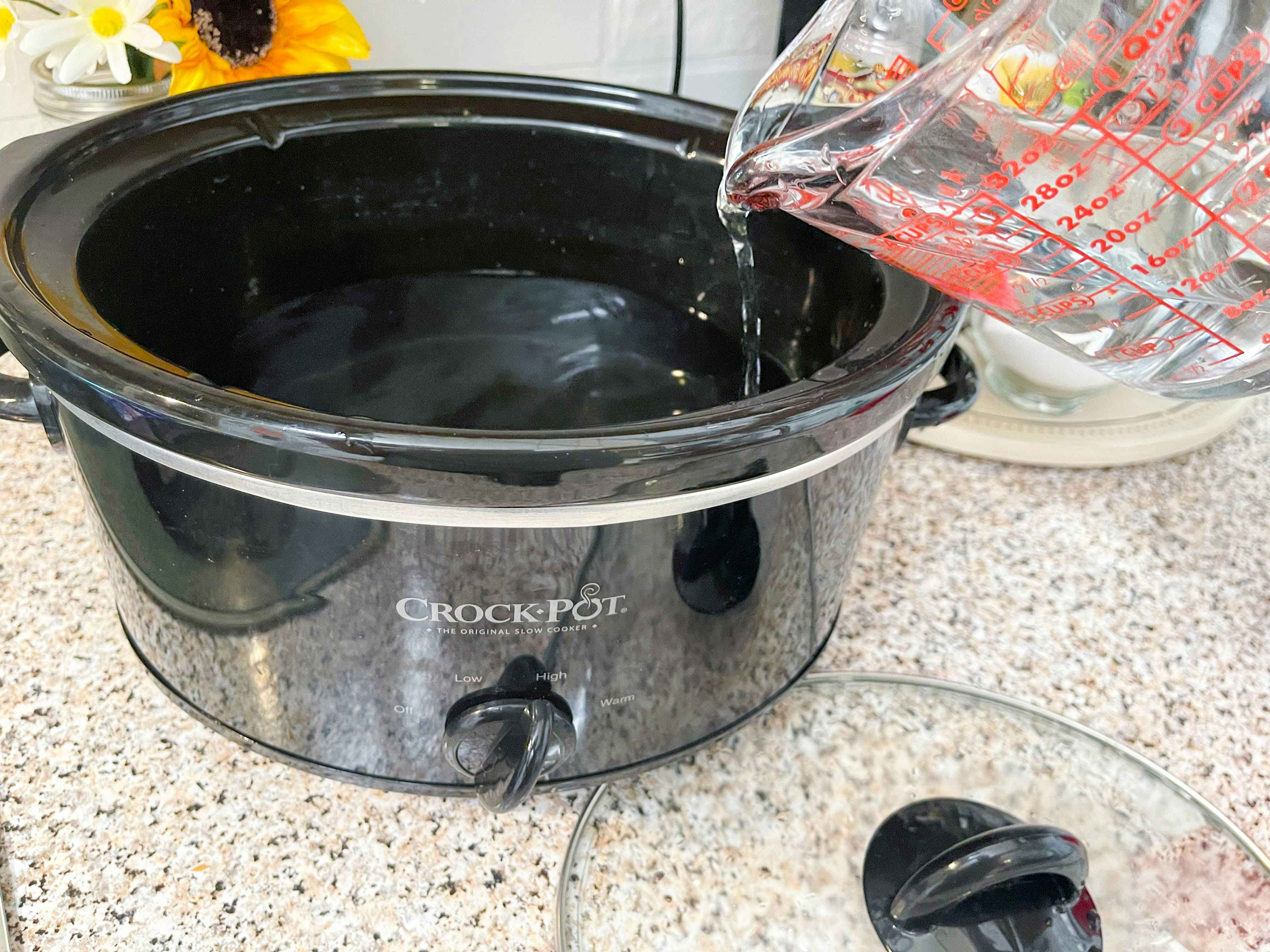 pouring water into slow cooker