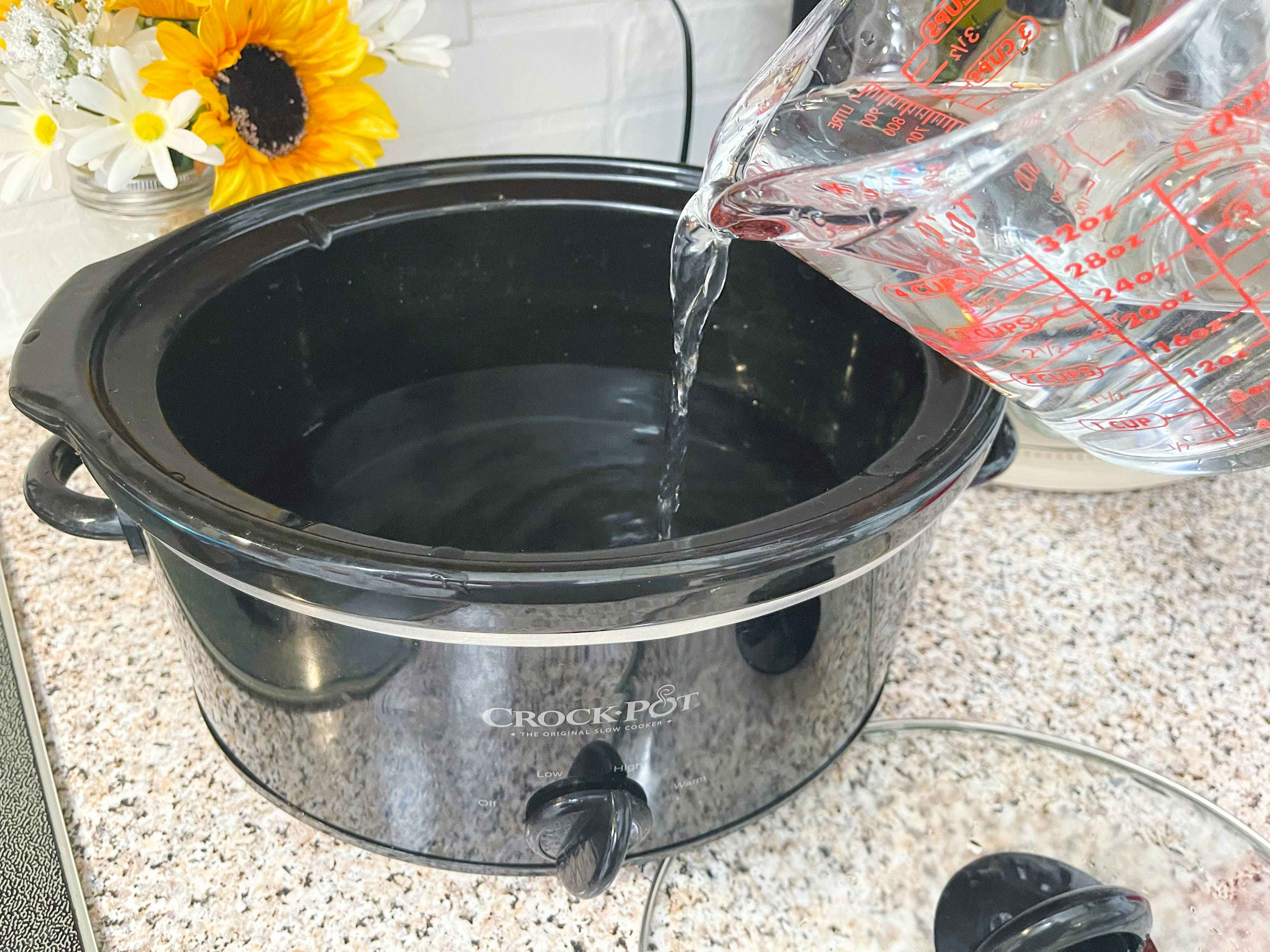 pouring water into slow cooker