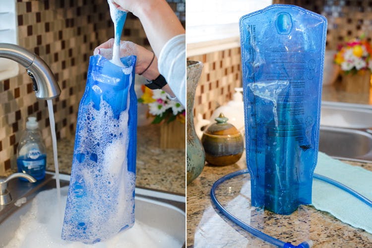 A water bladder being cleaned in a soapy sink.