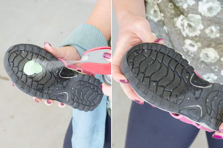 Person spraying a solution onto gum stuck on a shoe