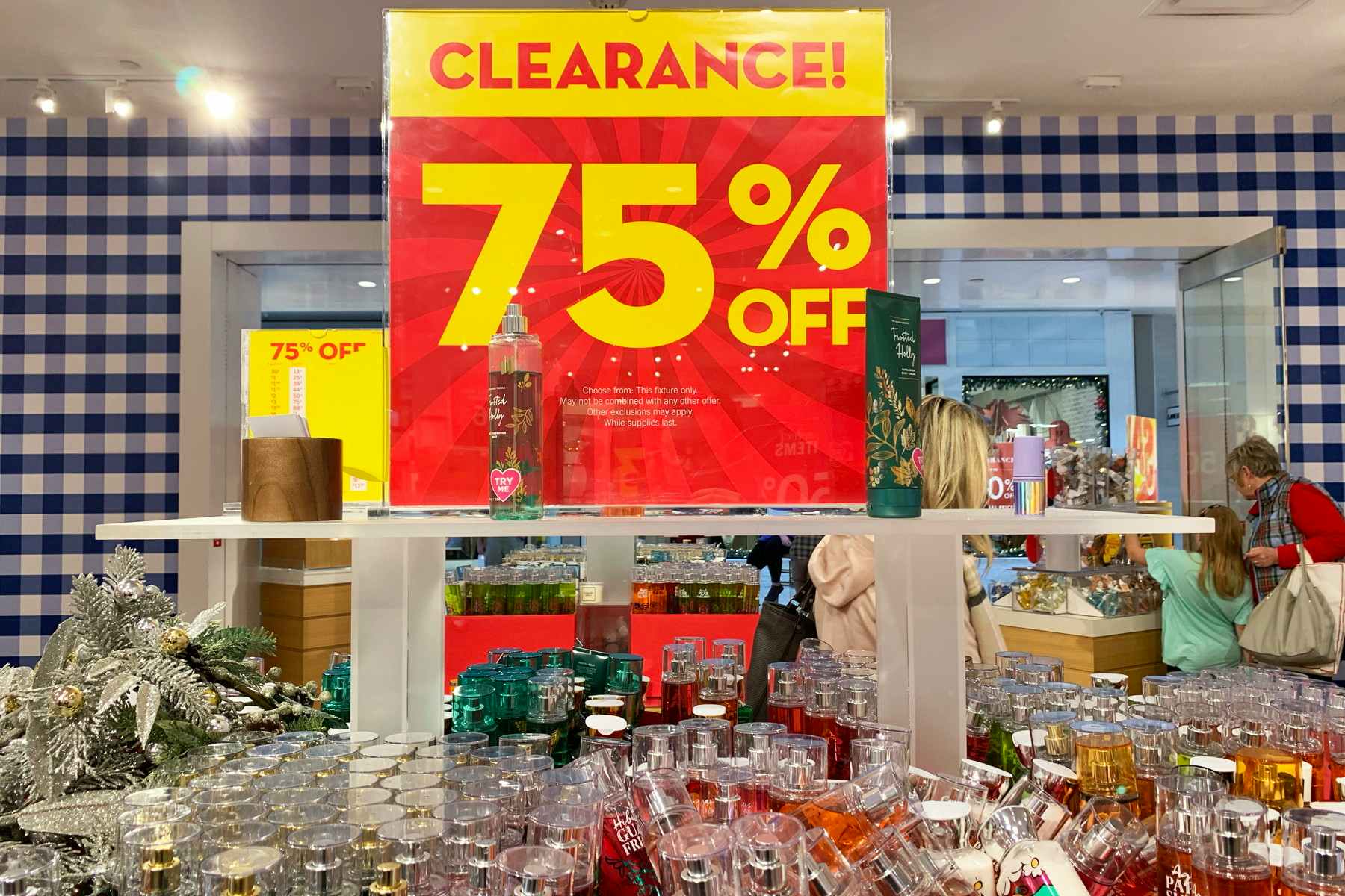 Bath & Body Works semi annual sale 75% off clearance sign on a shelf in the store.