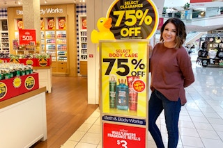 woman standing next to bath and body works clearance sign