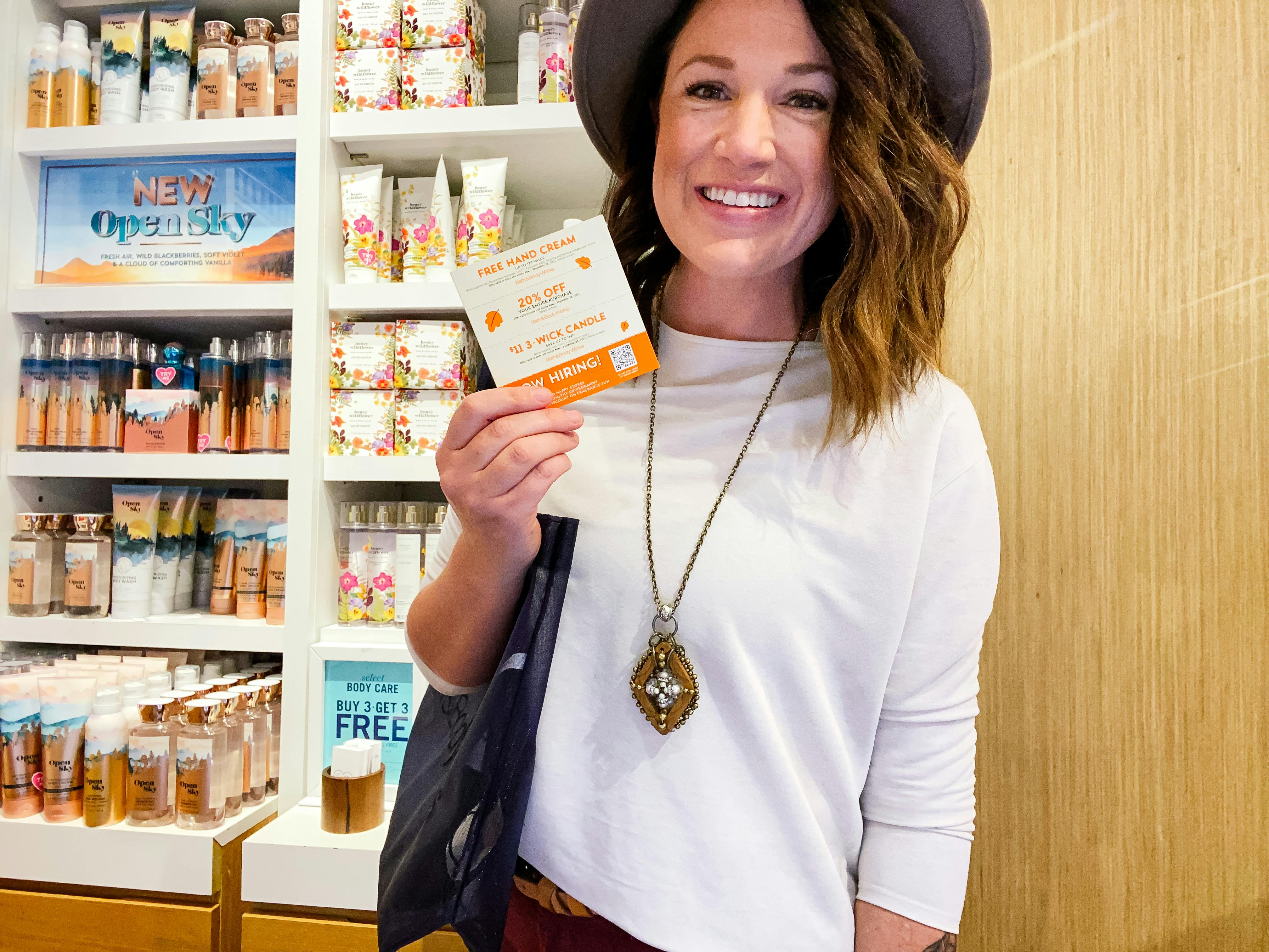 woman holding coupons at bath and body works