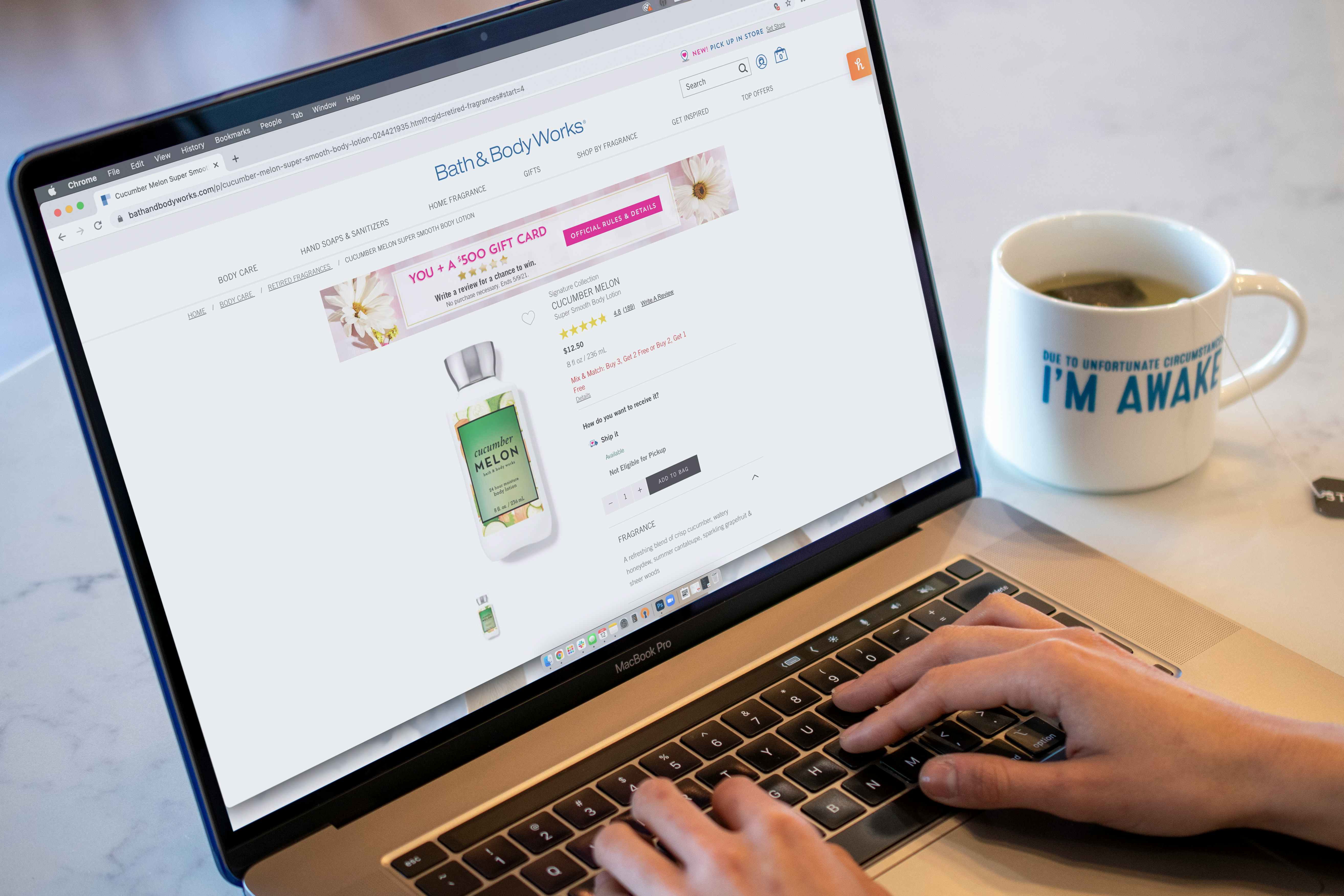 A person using a computer with Bathandbodyworks.com on the screen.