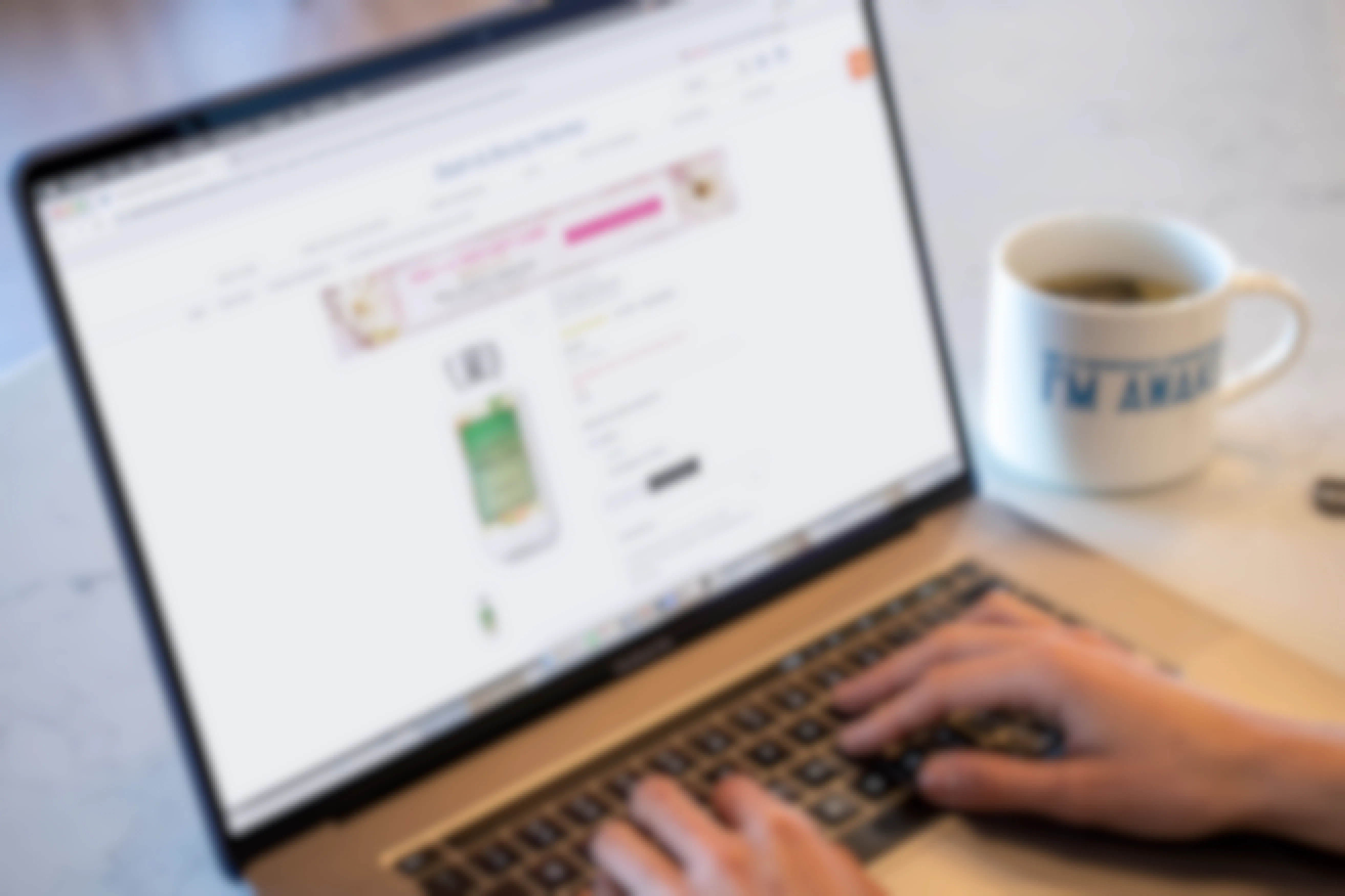 A person using a computer with Bathandbodyworks.com on the screen.