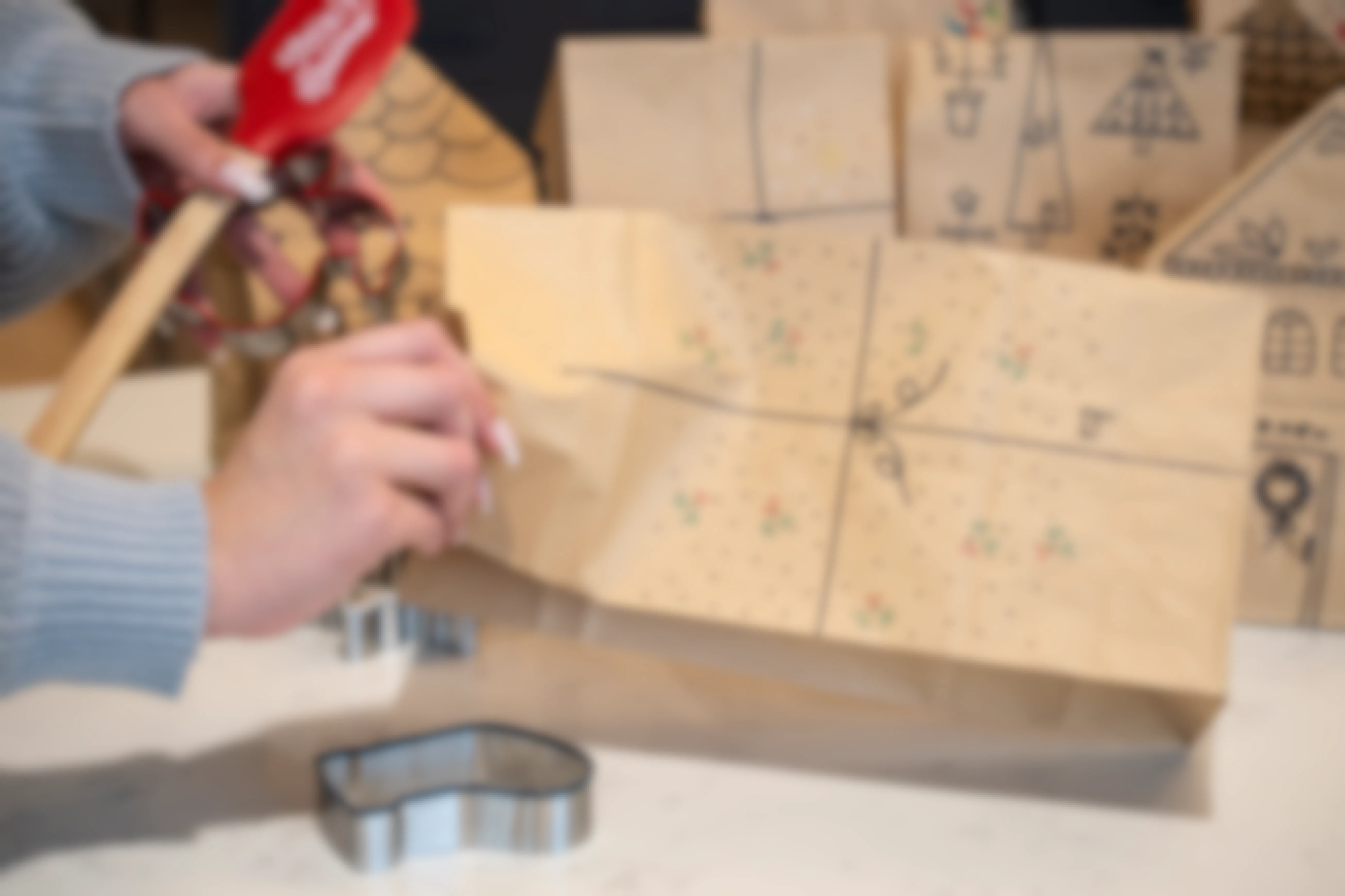 Someone putting baking supplies into a paper bag decorated for Christmas