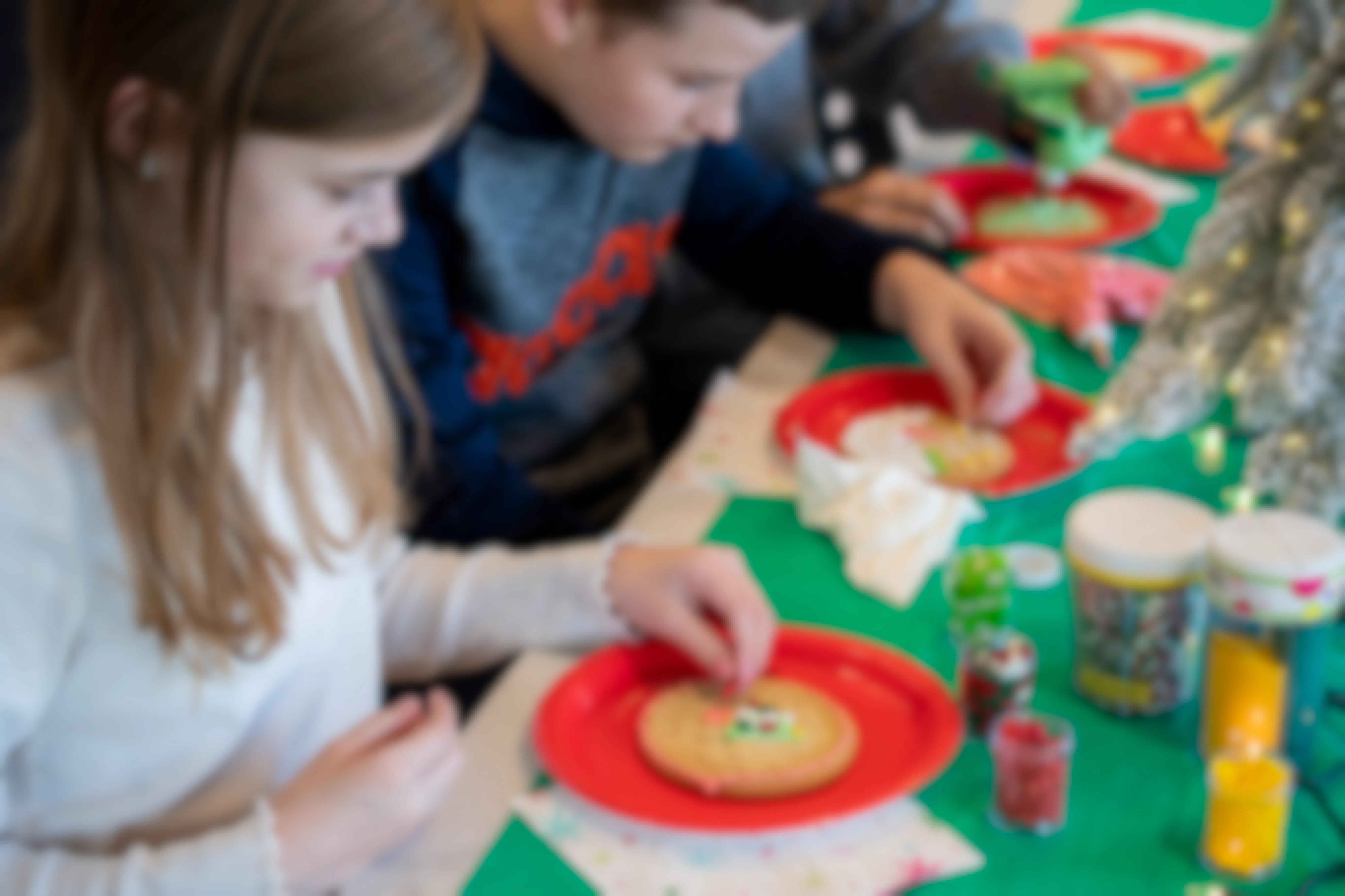 Some kids decorating Christmas Cookies at a table
