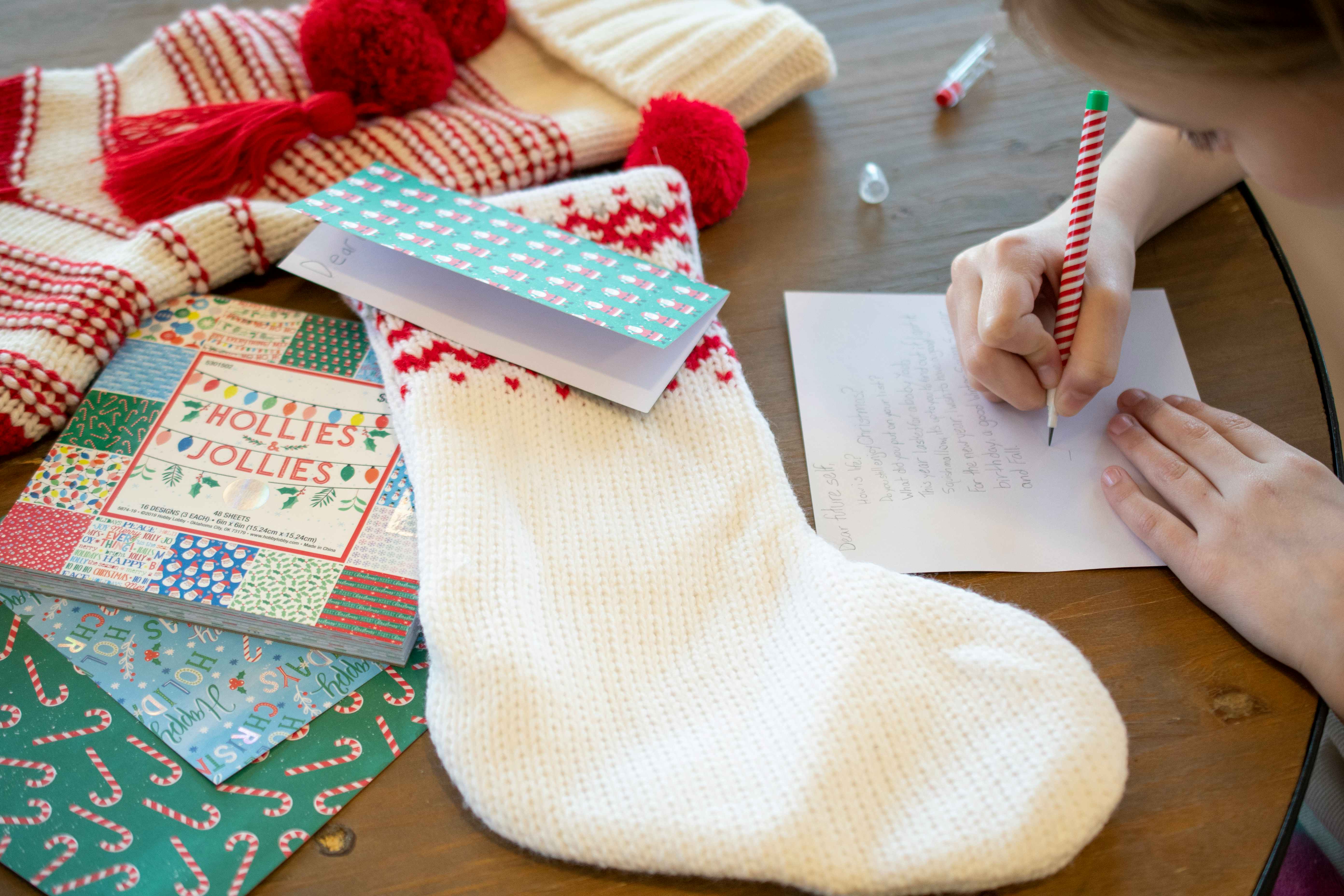 Kids writing notes on Christmas card stock and putting them in their stockings.