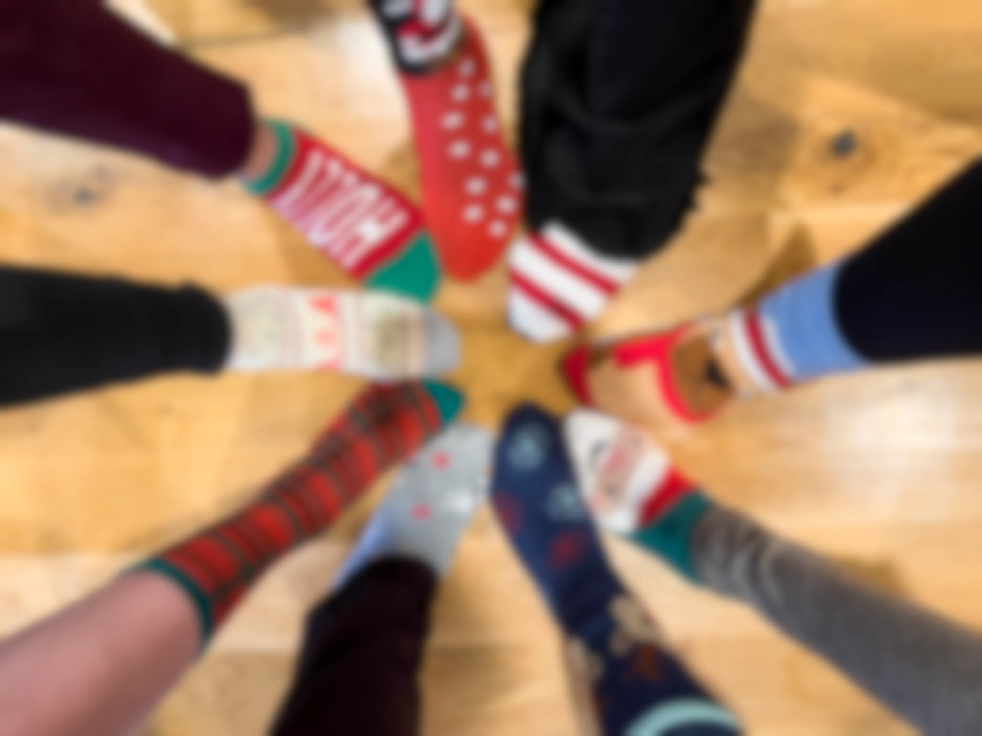 a bunch of peoples feet together in a circle, all wearing Christmas sock