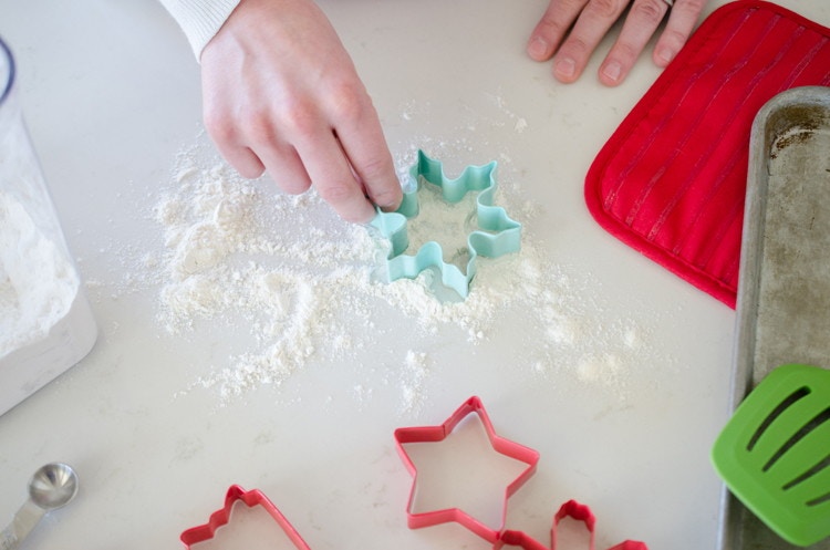 person-cutting-cookie-dough-with-cookie-cutter